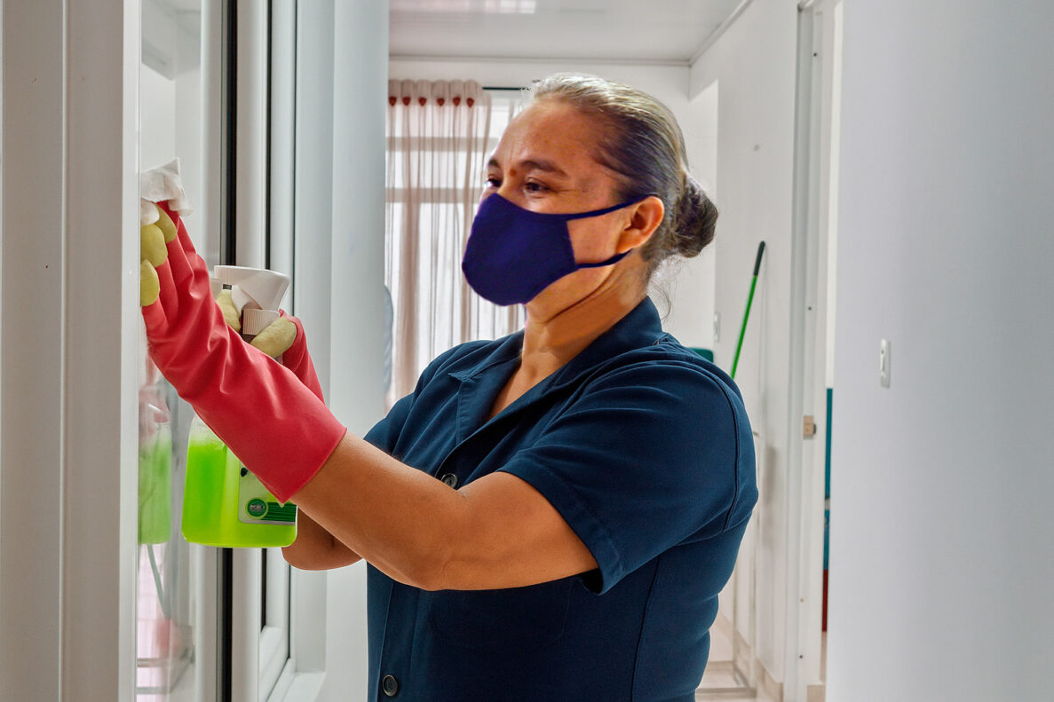 trabajadora de empresa de limpieza limpiado vidrios en una casa en Villavicencio - servicios de aseo para casas, hoteles y hospitales